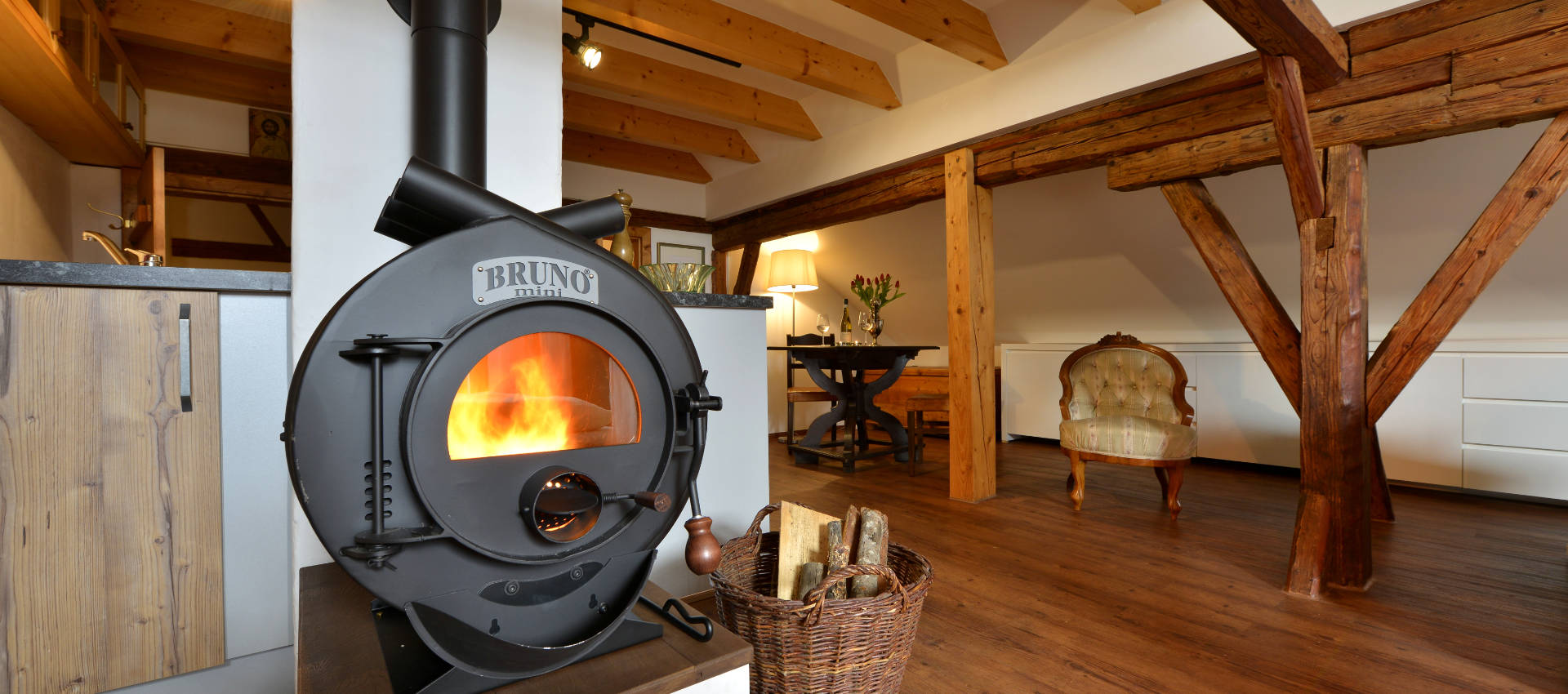 Herrschaft-Slider-1920×850-12 das herrschaftliche gemach - Bruno Holzofen - Sichtdachstuhl mit dunklen Holzbalken - Sitzecke