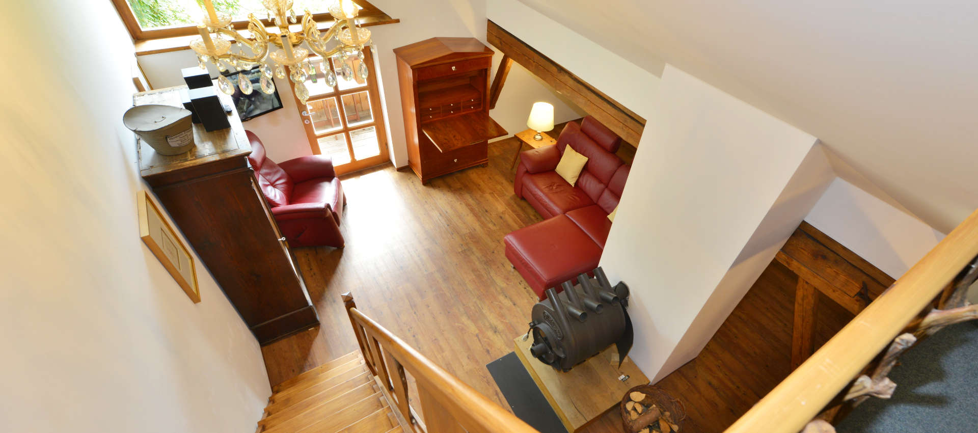 Die Klassikgalerie - Blick von der Galerie auf rote Couch und antike Möbel