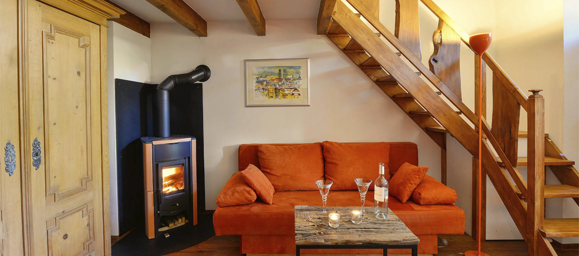 Die Kunstgalerie - orange Couch und Treppe zur Galerie